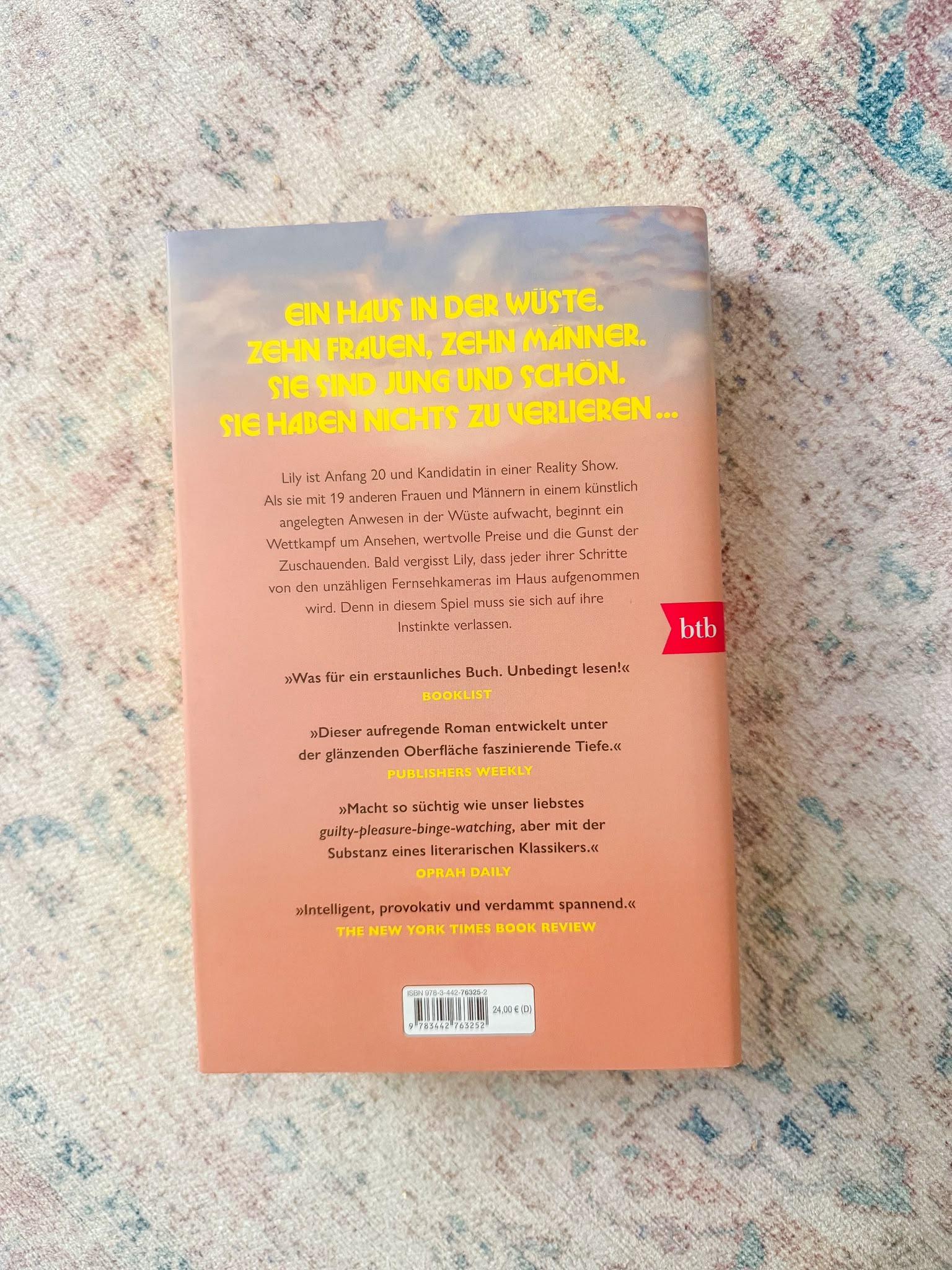 Das Spiel von Aisling Rawle Rezension Das Buch Das Spiel von Aisling Rawle auf einem Tisch mit sommerlicher Dekoration