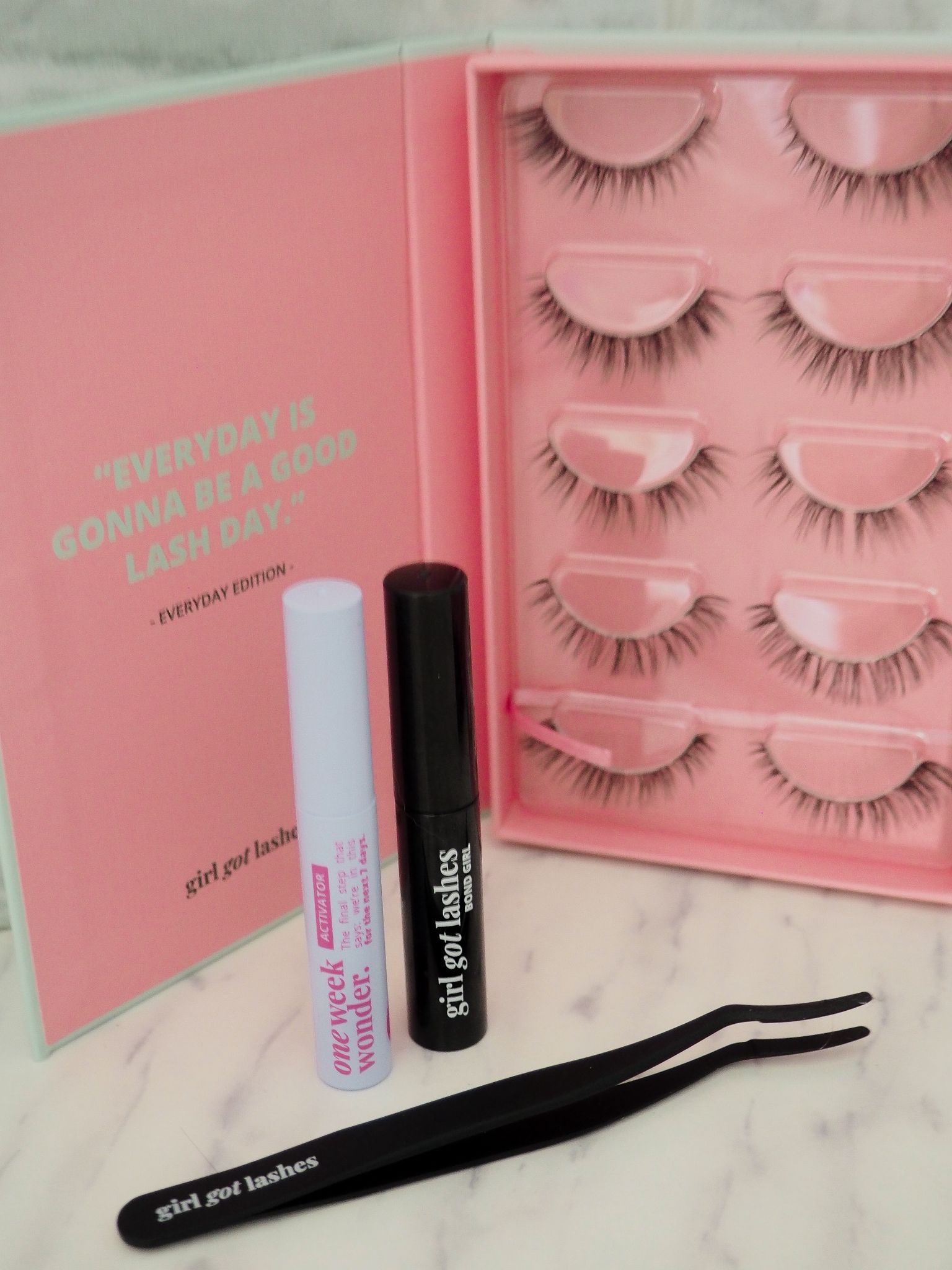 pre-glued-lashes-anwendung Frau bringt selbstklebende Pre-Glued Lashes mit einem Applikator unter den natürlichen Wimpern an.